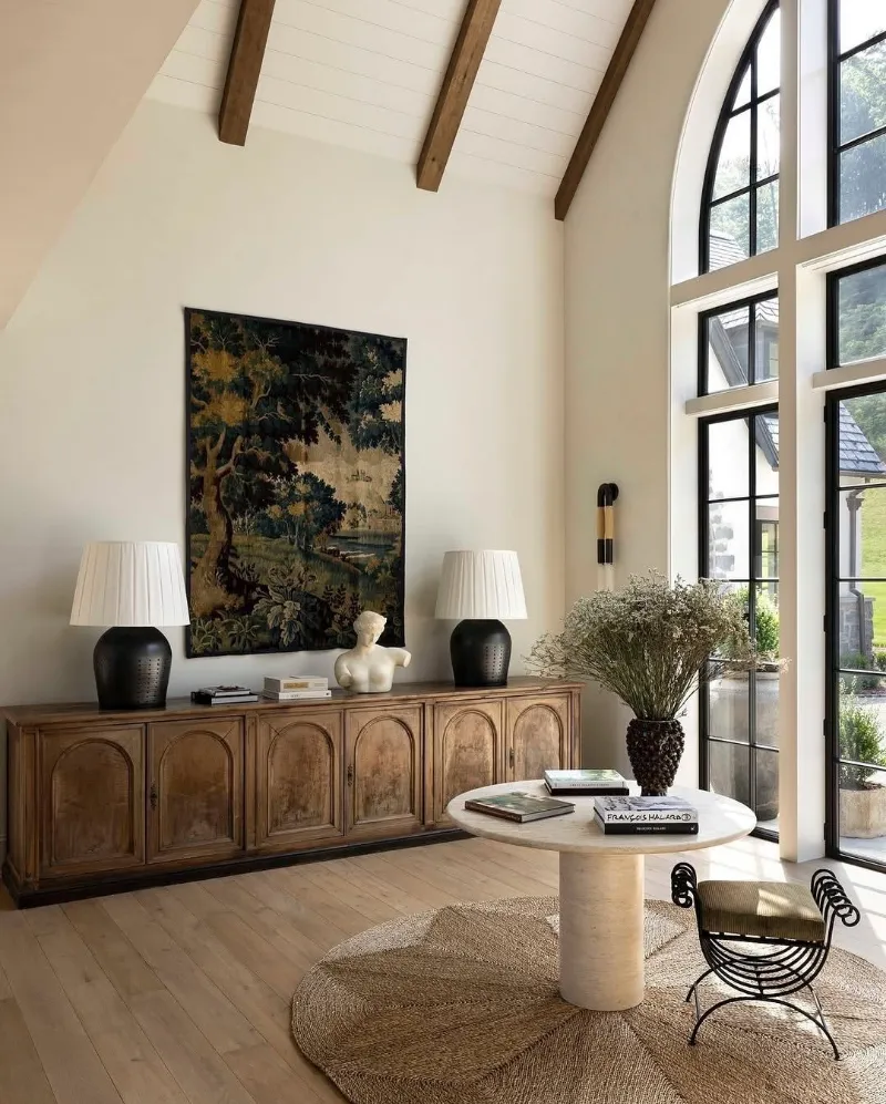 Salon sous une haute charpente, buffet en bois et tableau